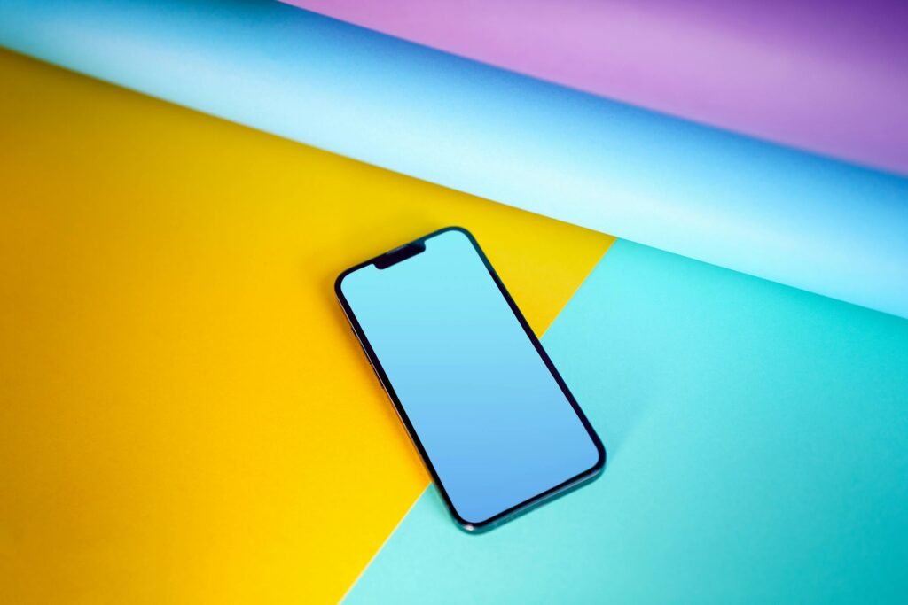 pexels-photo-17668053-17668053 Modern smartphone lies on a vivid, colorful background, emphasizing technology and design.